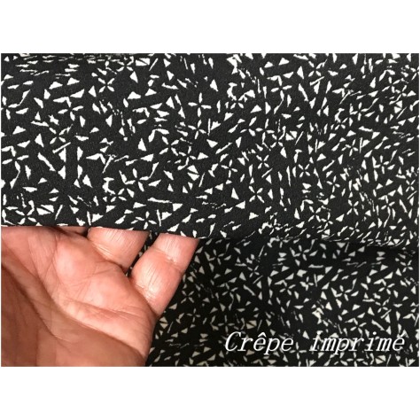 "Crêpe imprimé écru sur fond noir : Élégance intemporelle au mètre !"